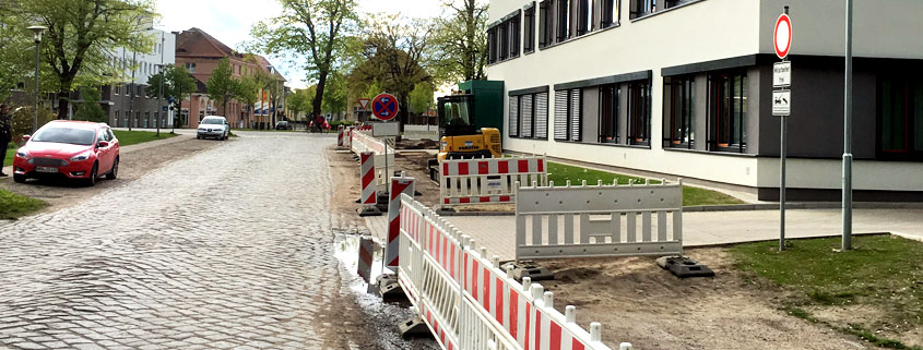 Absperrung eines Gehweges inklusive der Einfahrt zum Gebäude an einer Plastersteinstraße